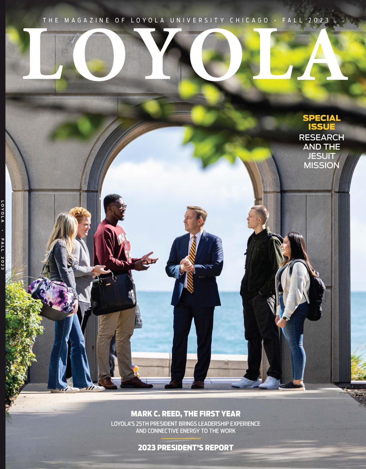 The fall 2023 issue of Loyola magazine with a group of people standing in front of an arch with a lake in the background and the text 