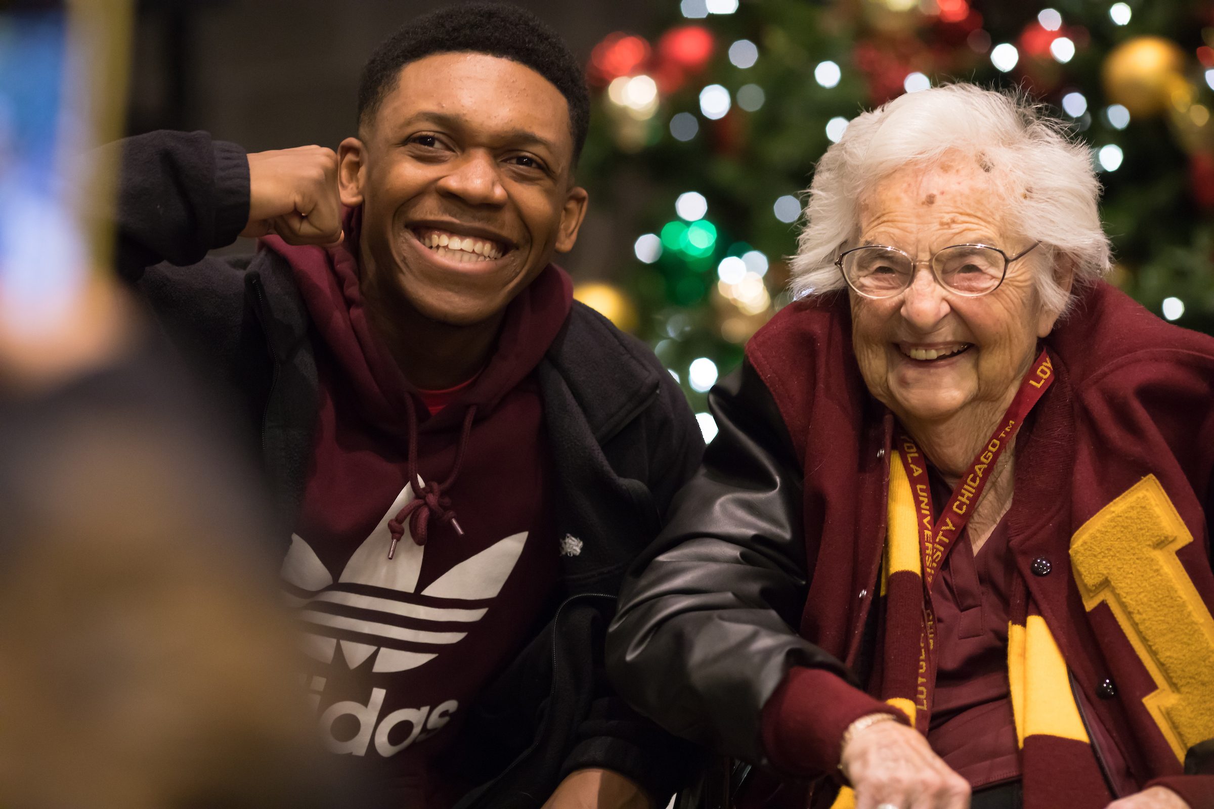 Loyola University Chicago students pose with Sister Jean Dolores Schmidt during the annual Christmas Tree Lighting Ceremony in the Damen Student Center on November 29, 2018. (Photo: Lukas Keapproth)