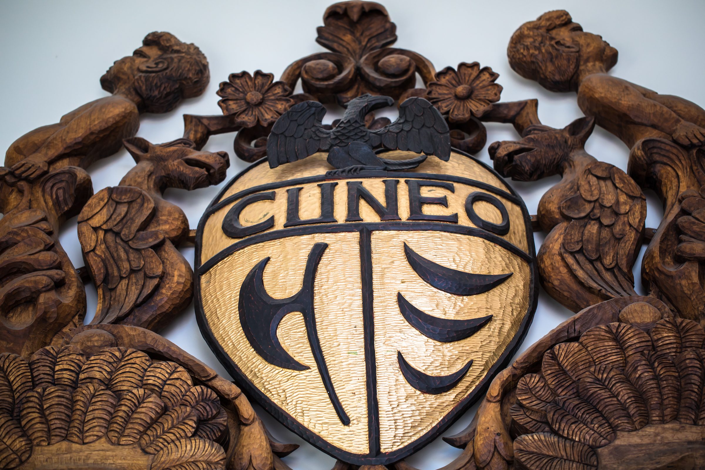 Cuneo family crest by Campbell “Camp” Bosworth of Texas; installed May 2012. The hand-carved wooden shield, made of black walnut and gold leaf, bears the Cuneo family crest. With elaborate half-moon faces, griffins, and cherubs, the crest measures 7.5 feet tall by 6.5 feet wide and weighs 350 pounds. It is in the entrance to Cuneo Hall and was created in honor of the Cuneo family, who have generously supported the University over the years. (Photo: Lukas Keapproth)
