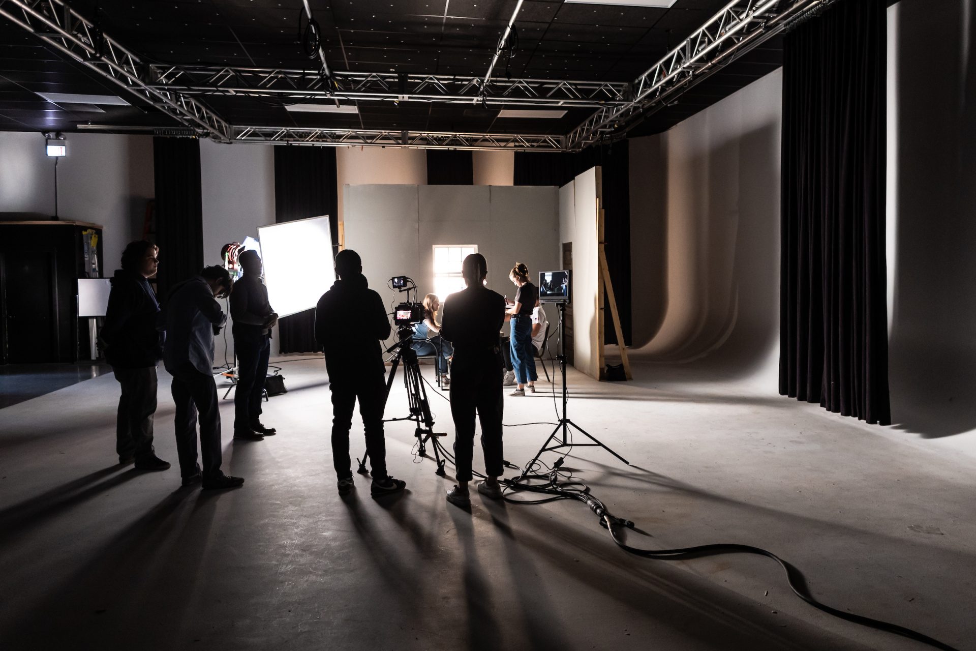 Professor working with students showing them lighting techniques in a film studio