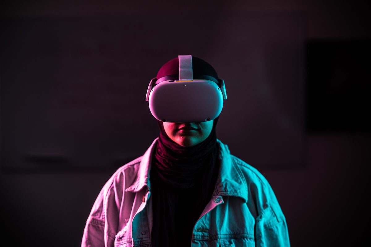 A woman wears a virtual reality headset in red and blue lighting