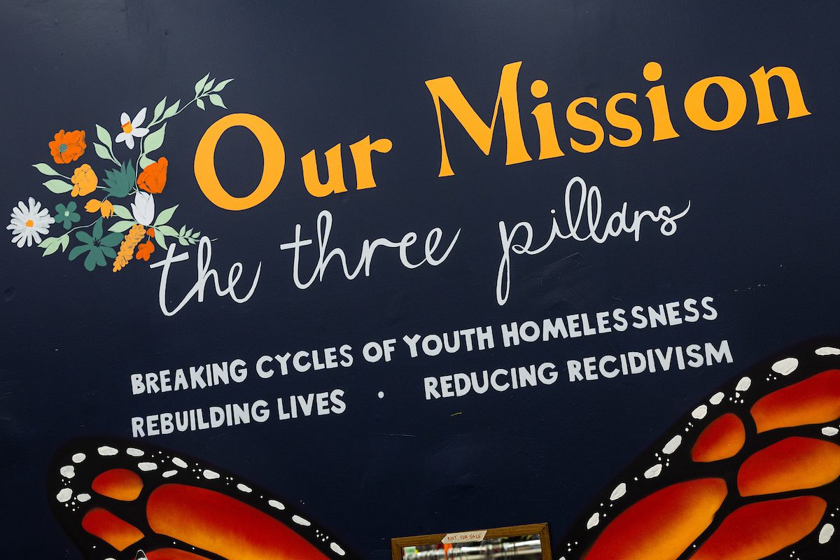 Monarch Thrift Shop's three mission pillars are painted on the wall above a monarch butterfly. (Photo: Lukas Keapproth)