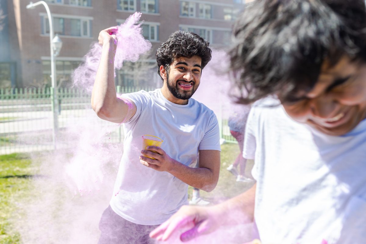 The Hindu Student Association hosts the annual Holi celebration in the Winthrop Play Lot, celebrating the arrival of spring, on April 6, 2024. (Photo by: Lukas Keapproth) A Loyola University Chicago student flings pink powder at another laughing student