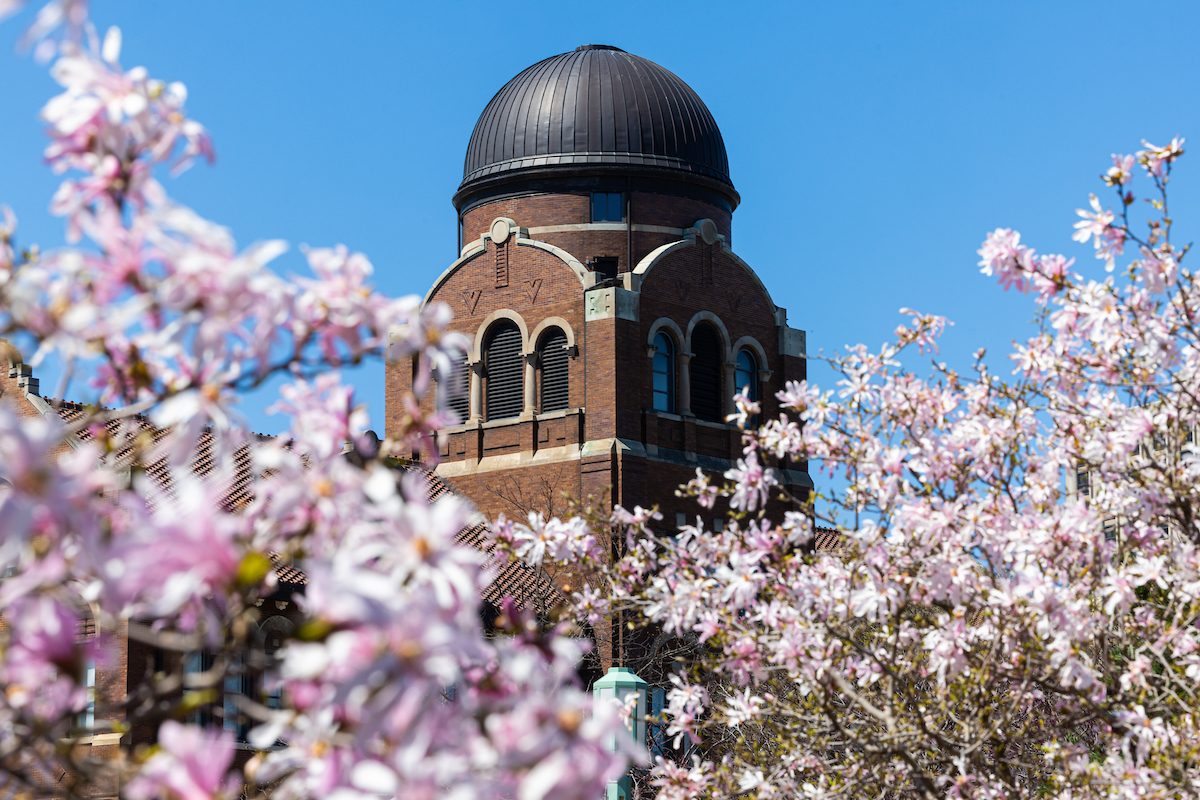 The Lake Shore Campus blooms with warmer spring weather, April 13, 2024. (Photo by: Lukas Keapproth) A red-brick building with a dome stands with blooming trees in the foreground