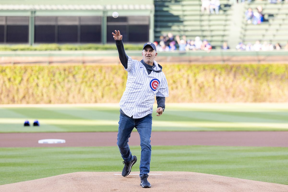 The Chicago Cubs host Loyola Night against the Houston Astros on April 26, 2024. (Photo by: Lukas Keapproth) A man wearing a Chicago Cubs baseball hat and jersey throws a pitch on the mound at Wrigley Field