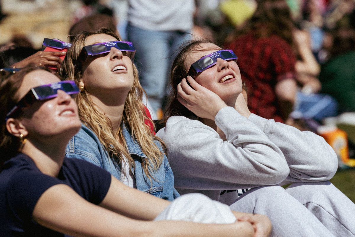 Loyola University Chicago students use eclipse glasses to view the solar eclipse on the West Quad of the Lake Shore Campus.