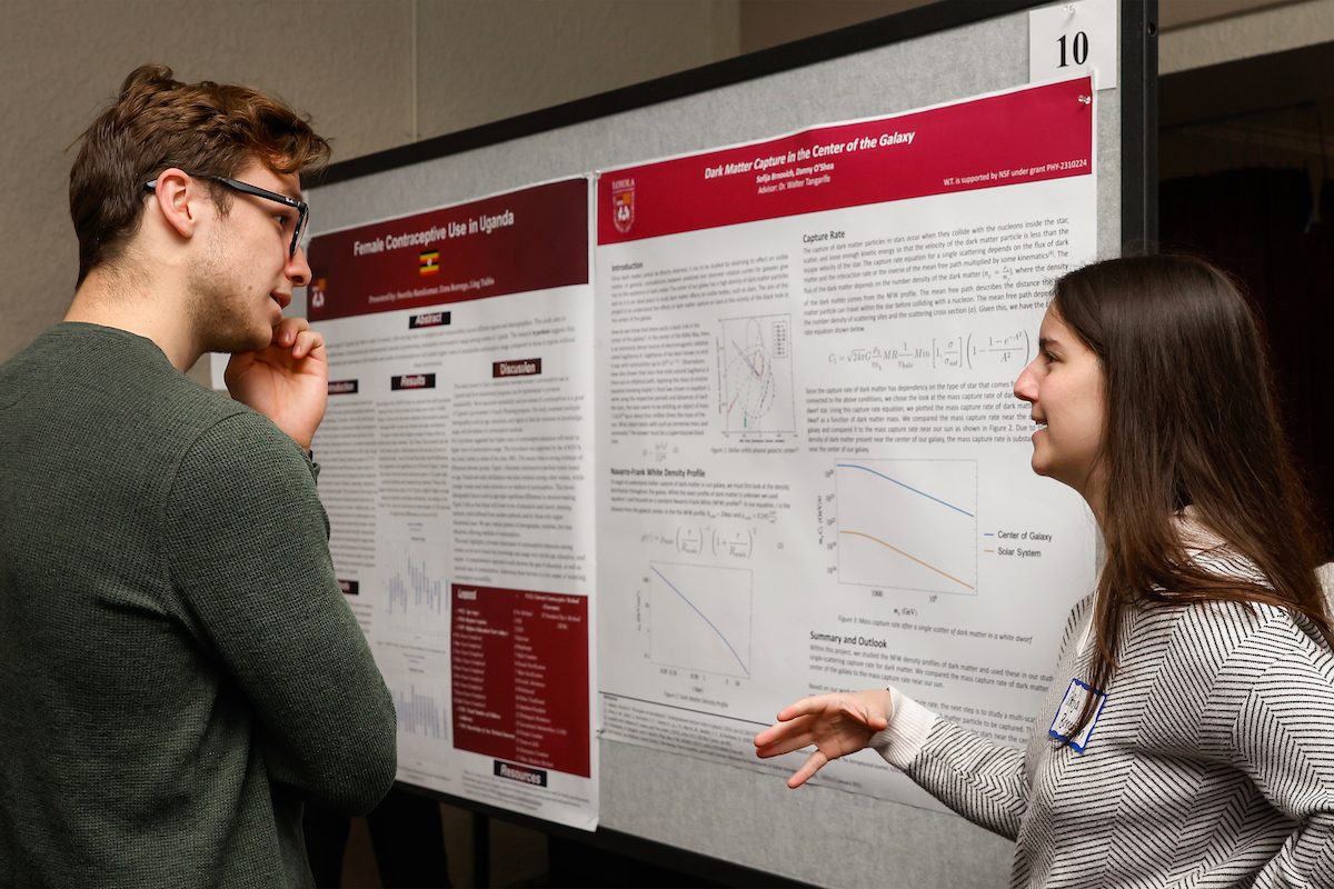 Poster Competition Session 1
Undergraduate Research and Engagement Symposium at Loyola University, April 20, 2024. A Loyola University Chicago student explains a project to another student with a presentation board in the background
