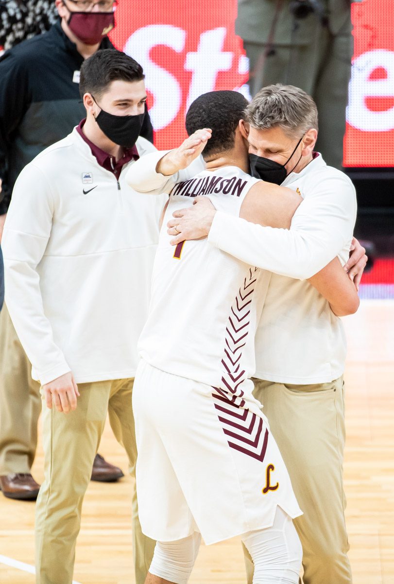 Clayton Custer watches as Coach Porter Moser embraces Lucas Williamson after winning the Missouri Valley Conference title. (Photo: Lukas Keapproth)