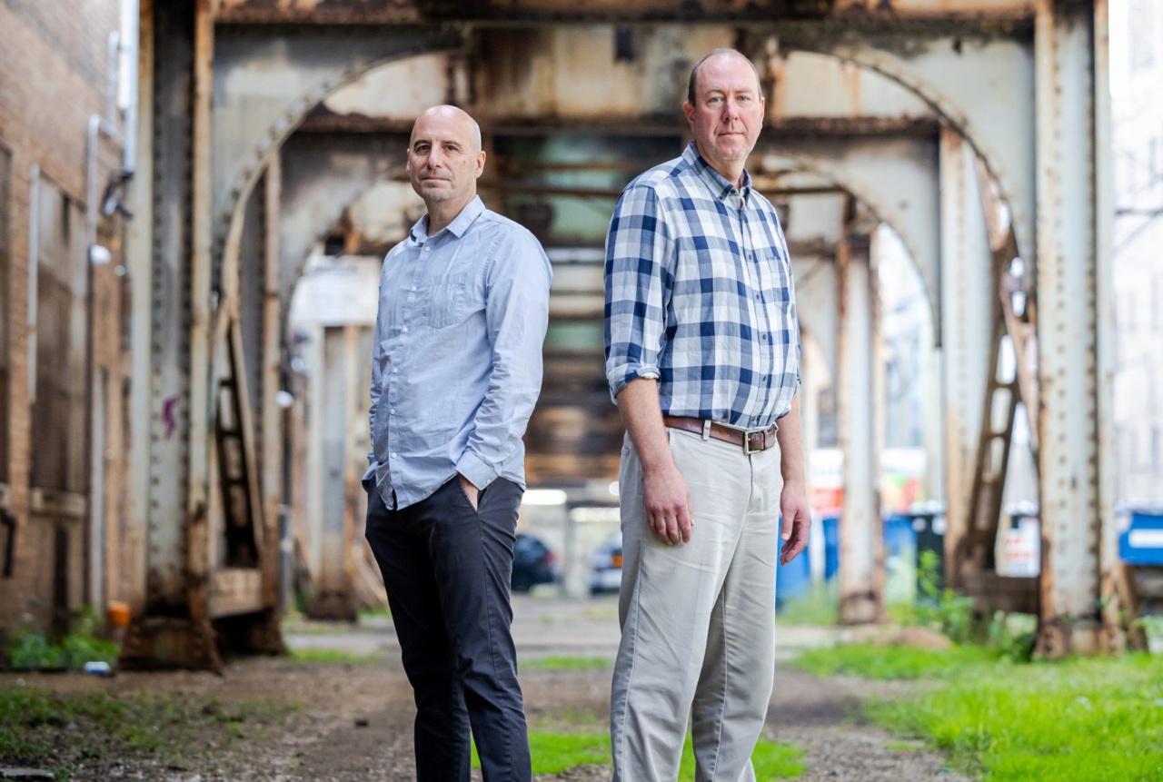 Two Loyola University Chicago professors stand under Chicago's elevated train tracks