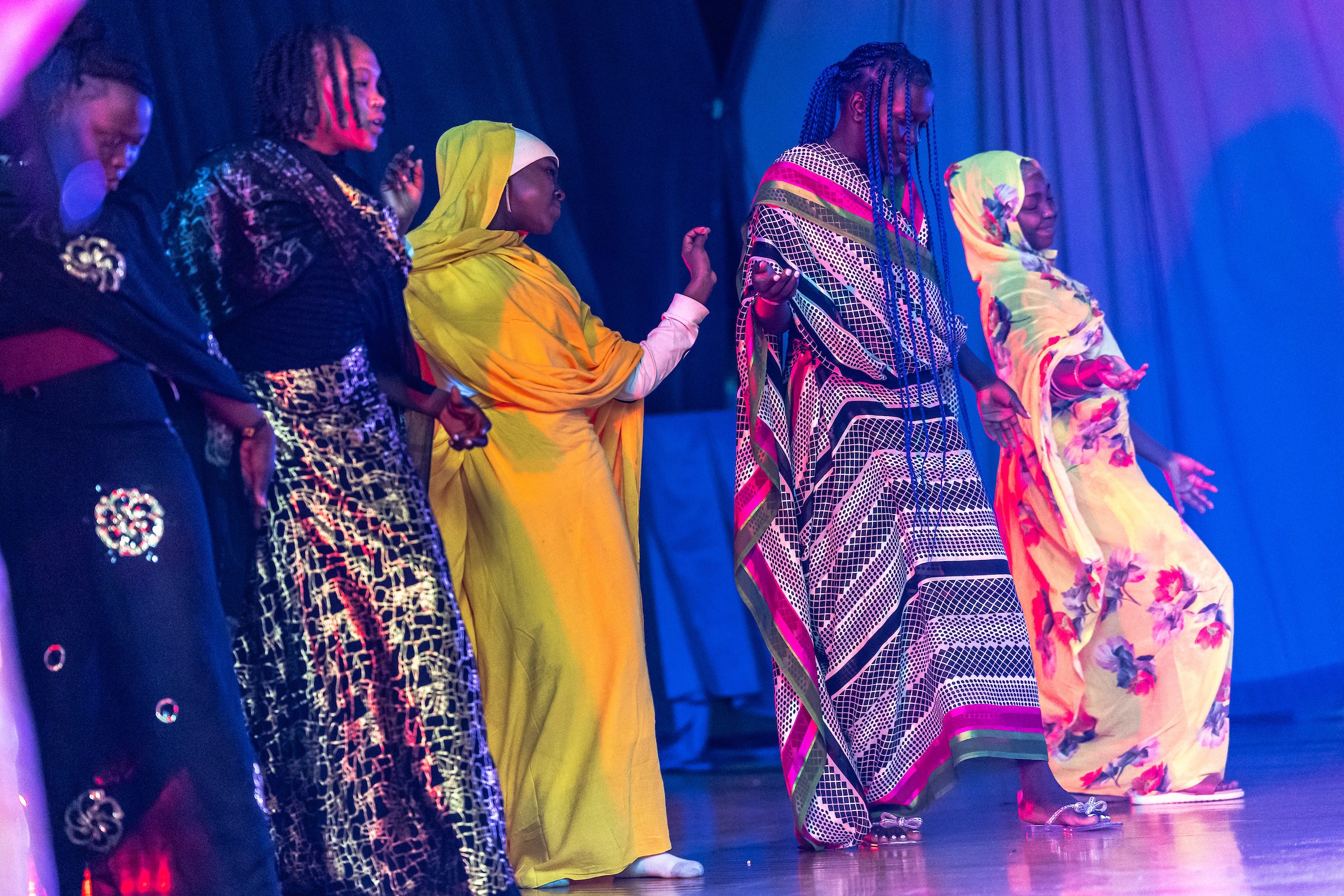 Students at Sullivan High school dance on a stage with blue lighting