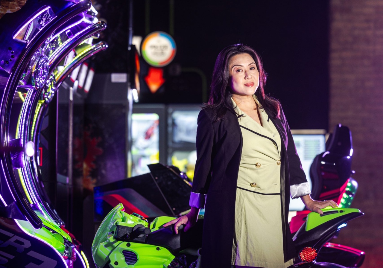 A Loyola University Chicago professor leans against a motorcycle in an arcade