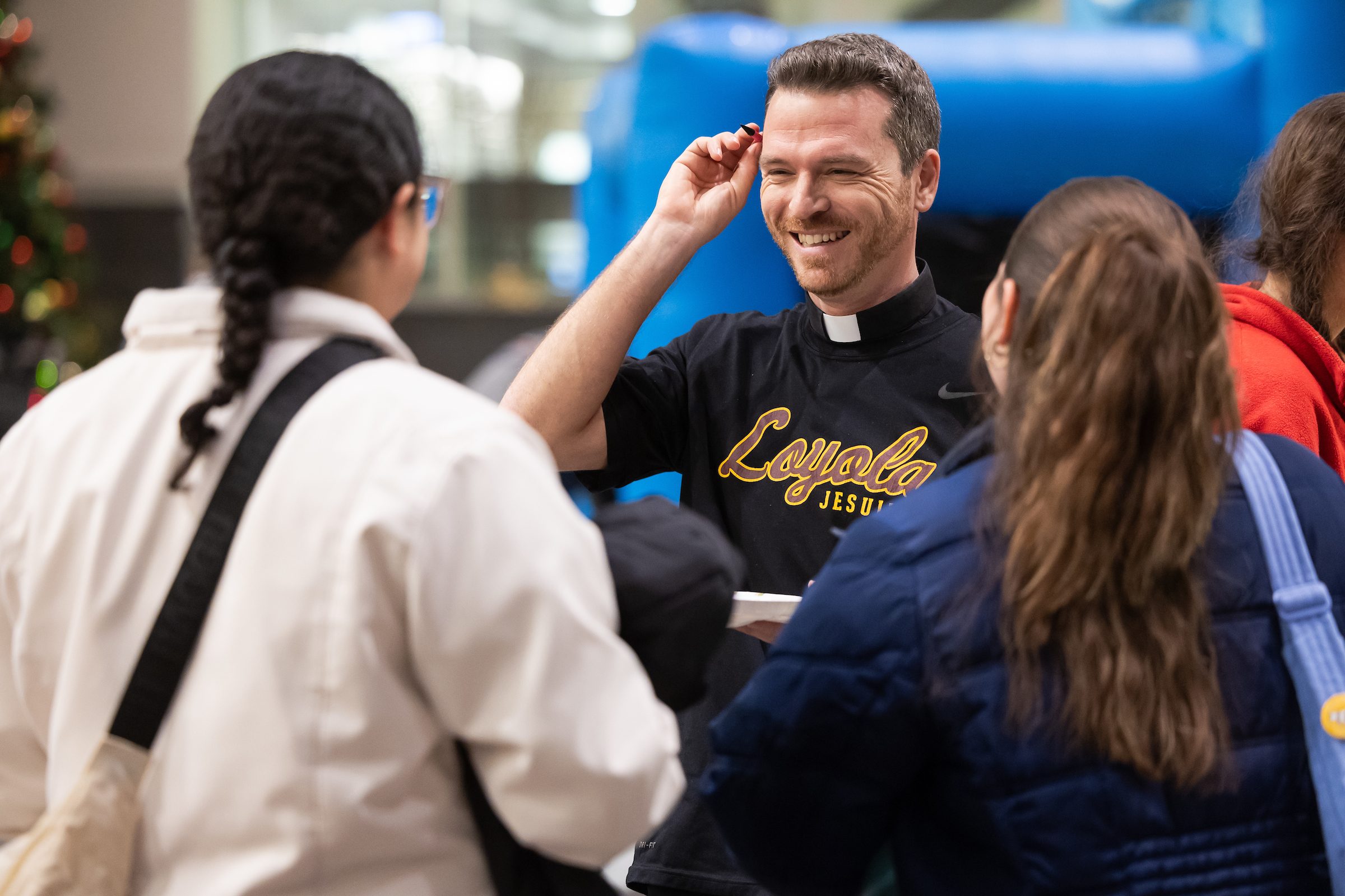 Loyola University Chicago students competed in Jesuit Bingo to learn about the Jesuit community on campus at the Jesuit Jam on Jan. 22. A man wearing a clerical collar speaks with Loyola University Chicago students at an event on campus