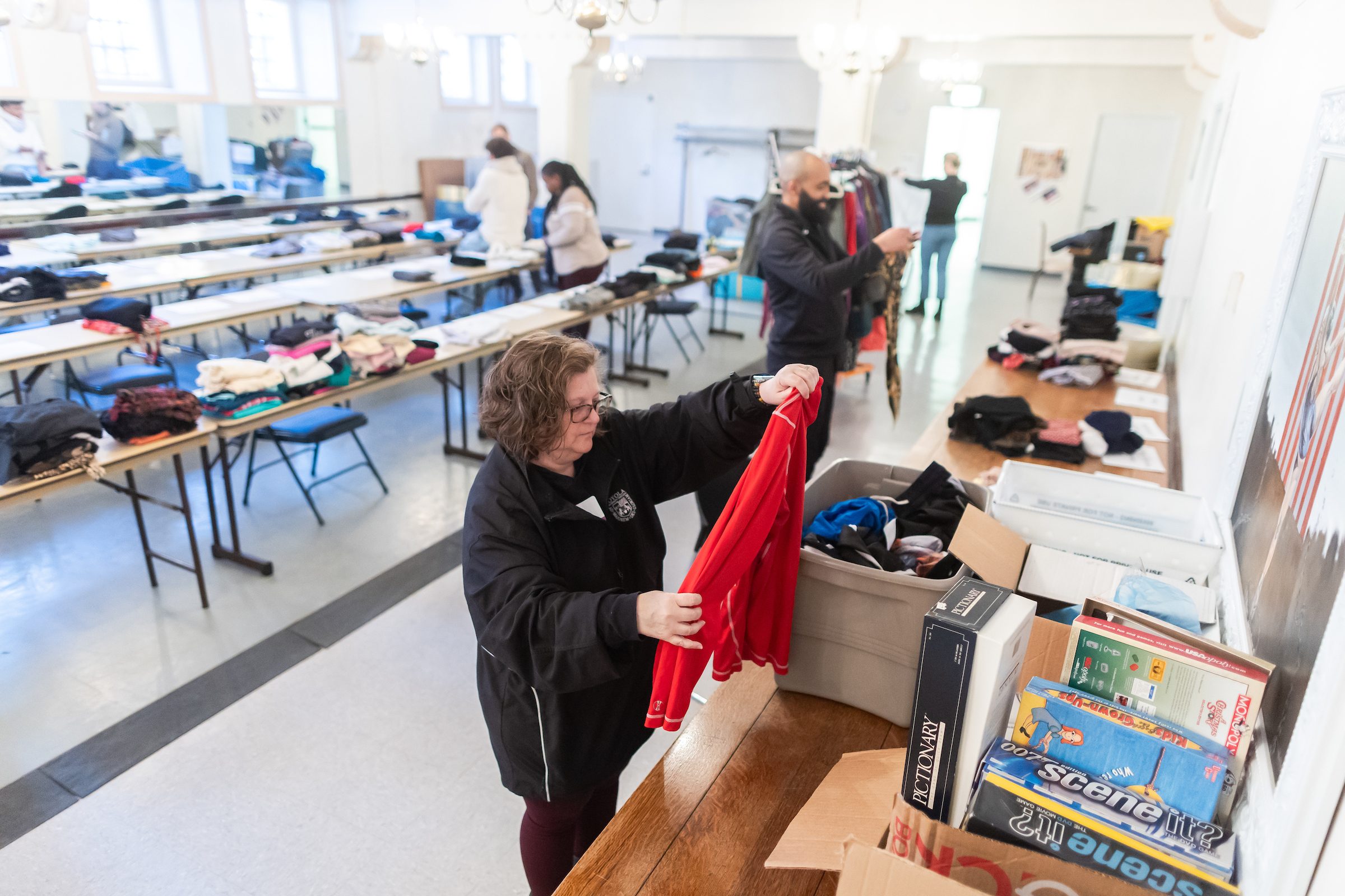 Loyola University Chicago staff and students volunteer at Chicago Lights to sort donated clothing for people experiencing homelessness as part of Martin Luther King Service Days, January 23, 2025. Loyola University Chicago faculty and students sort through donated clothing on folding tables