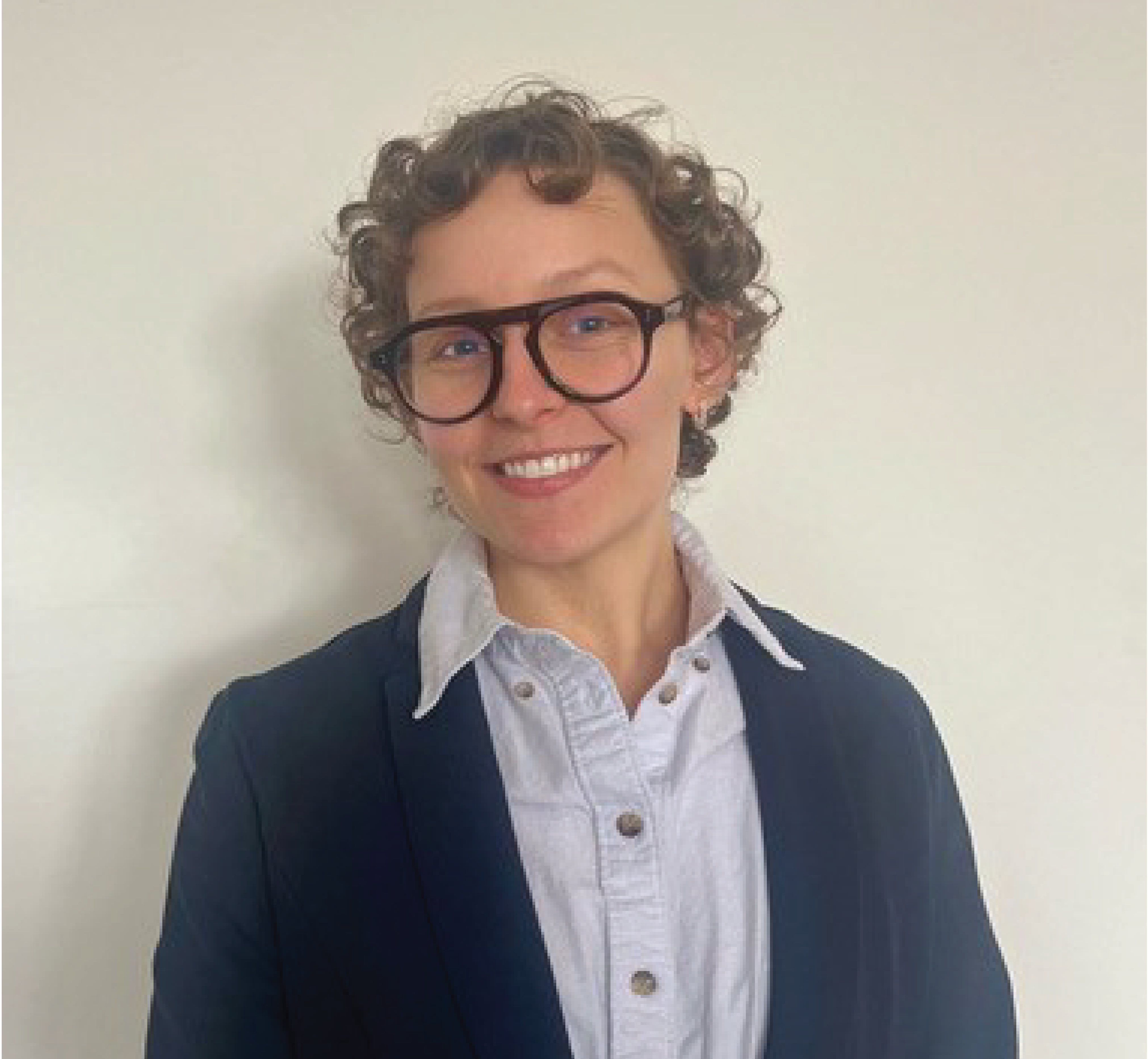 Loyola University Chicago rising senior Brady Mudge. Loyola University Chicago rising senior Brady Mudge faces the camera with glasses, a blazer, and button down shirt.
