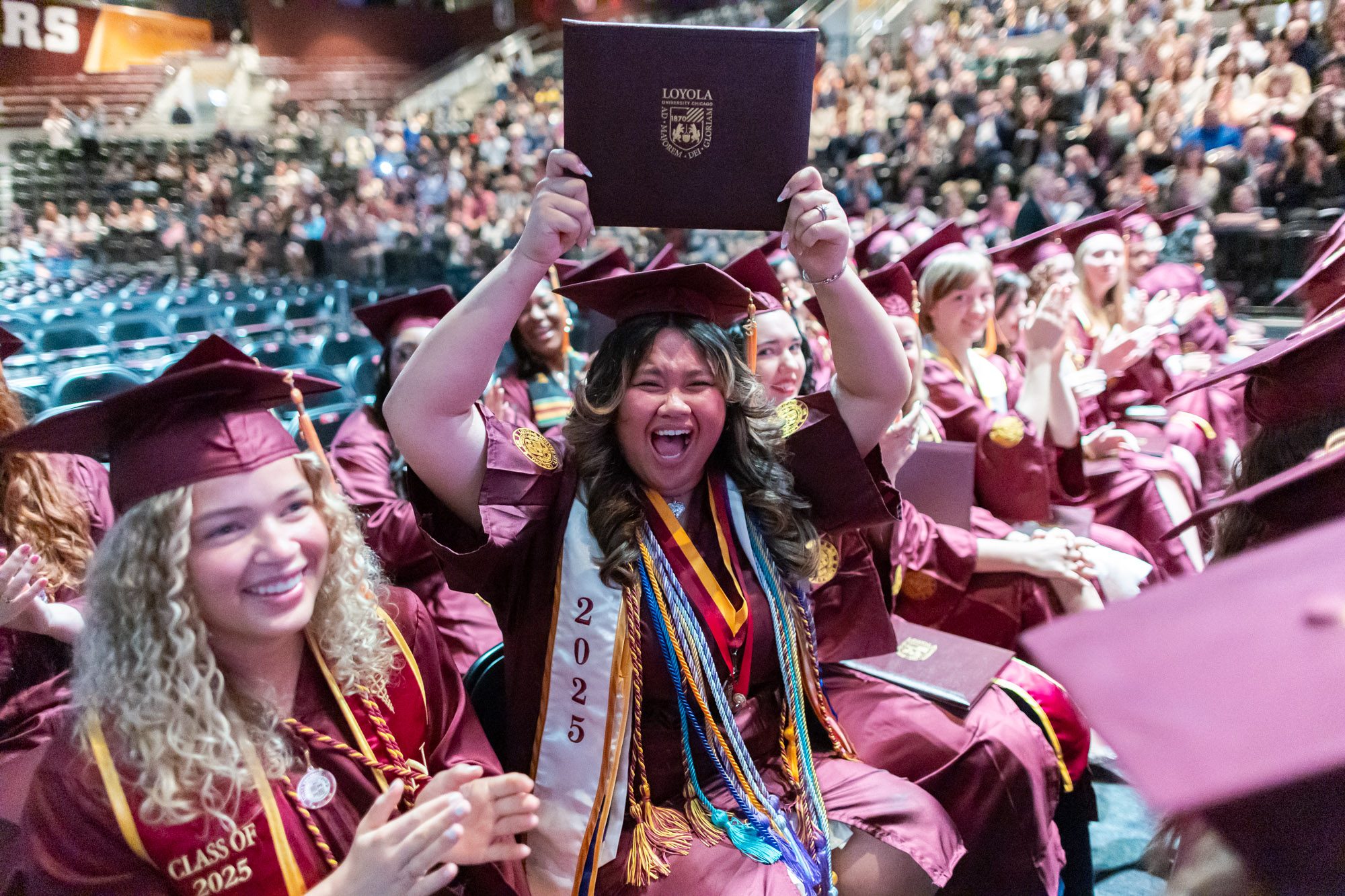 Kyla Santos, graduate from the Marcella Niehoff School of Nursing, proudly shows off her diploma after walking across the stage.