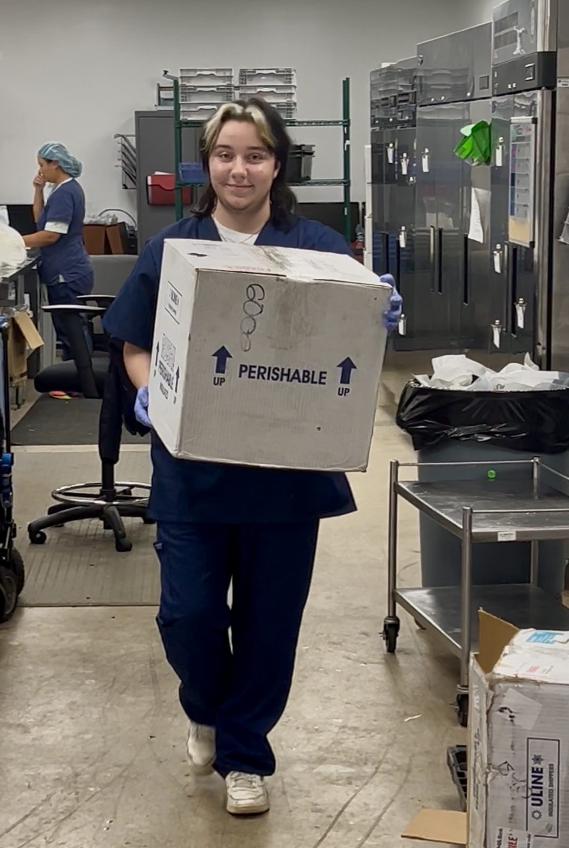 Hollis Kolb (BA ’28) carries a box at his summer job at The Milk Bank, where he worked to prepare breast milk for distribution to NICUs in hospitals across the Midwest.