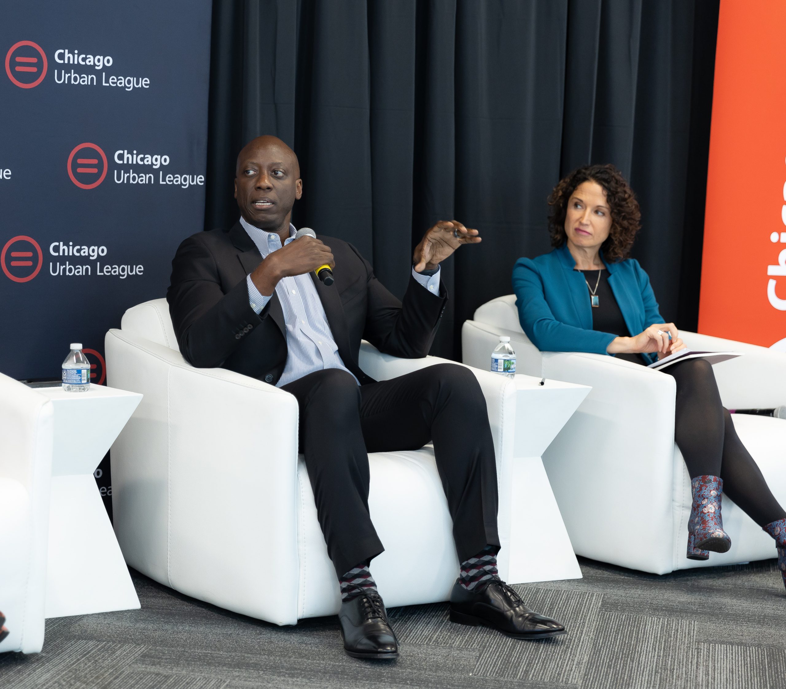 Malik S. Henfield, founding dean of Loyola's Institute for Racial Justice, and Marisa Navaro, vice president for community impact at Chicago Community Trust, participate in a panel discussion on the Chicago Urban League's 2023 State of Black Chicago report hosted by Chicago Urban League and Loyola's Baumhart Center in October 2023.