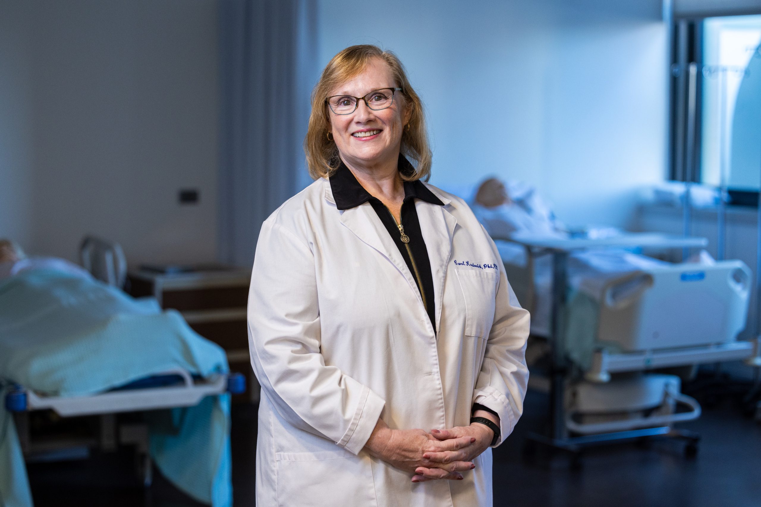 Carol Kostovich stands in the Loyola Simulation Lab, where students gain hands-on nursing presence experience.