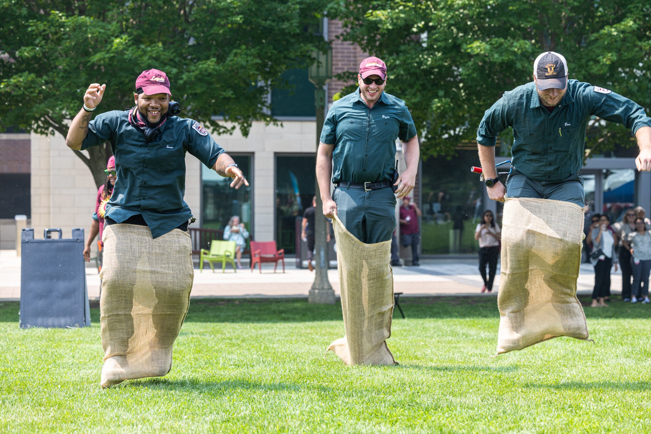 Members of Campus Facilities compete in a sack race, one of many recreational events that took place during the Feast of Saint Ignatius on the West Quad in July.