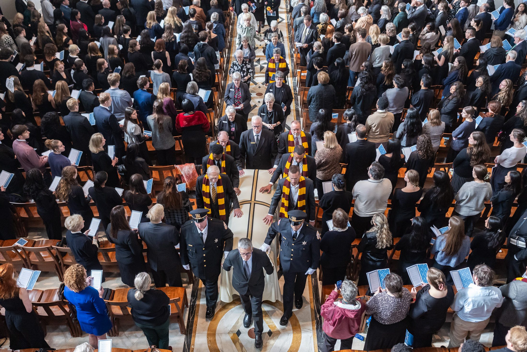 Members of the Sisters of Charity of the Blessed Virgin Mary community, along with basketball players, athletic leaders, and campus police lieutenants, escorted the casket of Sister Jean Dolores Schmidt, BVM, out of the chapel during her funeral Mass on Oct. 16, 2025.