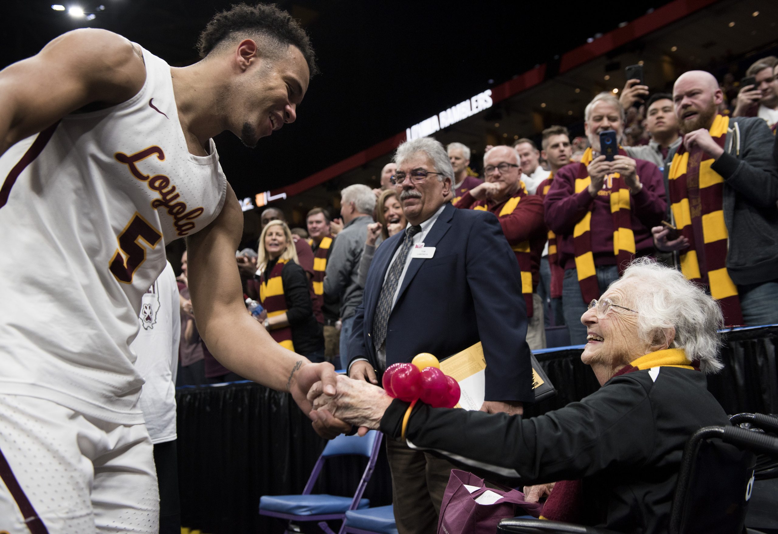 Ramblers men's basketball player Marques Townes shakes hands with Sister Jean Dolores Schmidt, BVM, after the Ramblers topped Bradley University during the semifinals of the Missouri Valley Conference men's basketball tournament in St. Louis on March 3, 2018. (Photo: Sid Hastings)