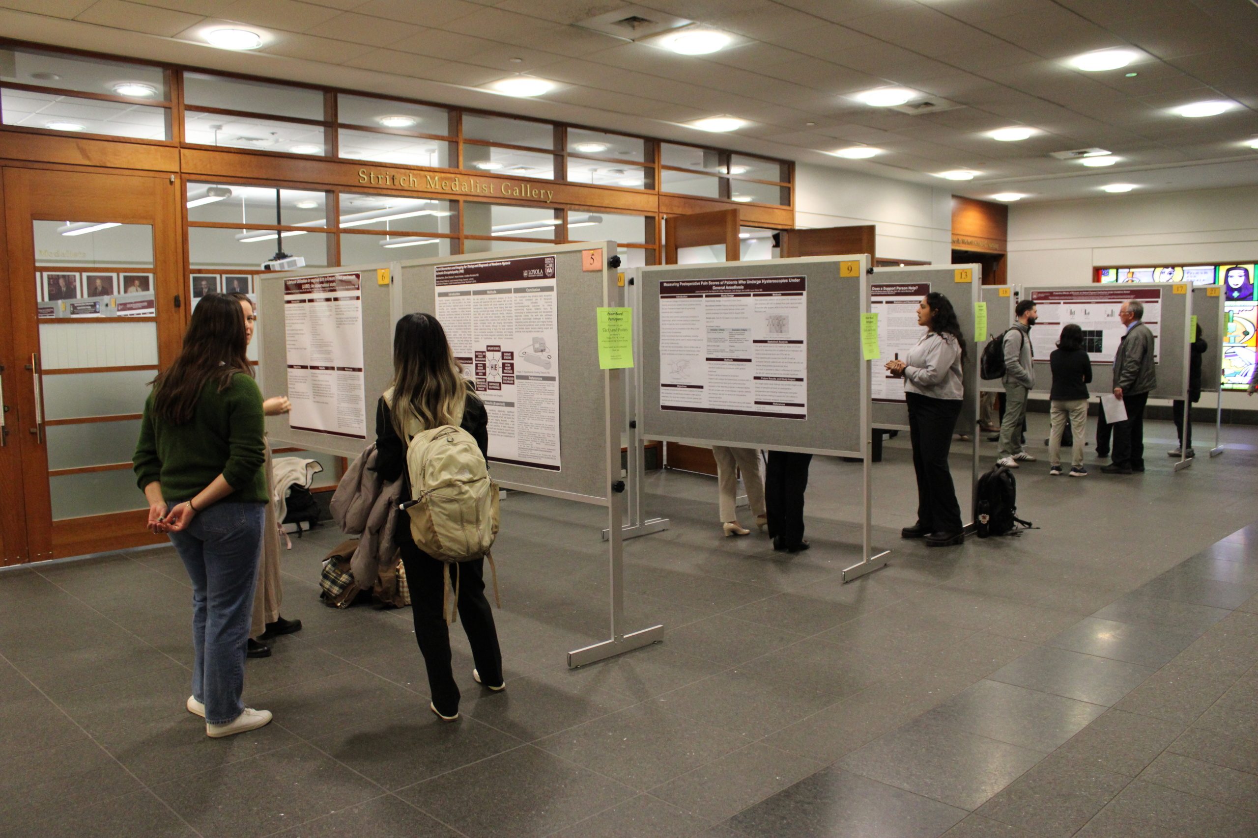 Header image and above: Visitors to the 45th St. Albert’s Day research symposium view posters on display near the Stritch Medalist Gallery. 
