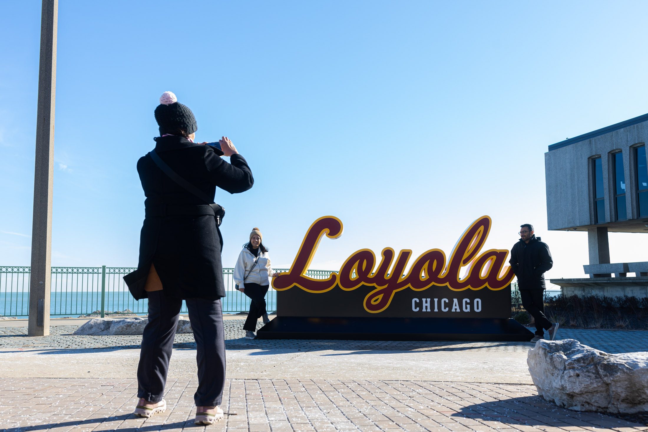 Prospective students pose near a new photo installation across from the Sullivan Center.
