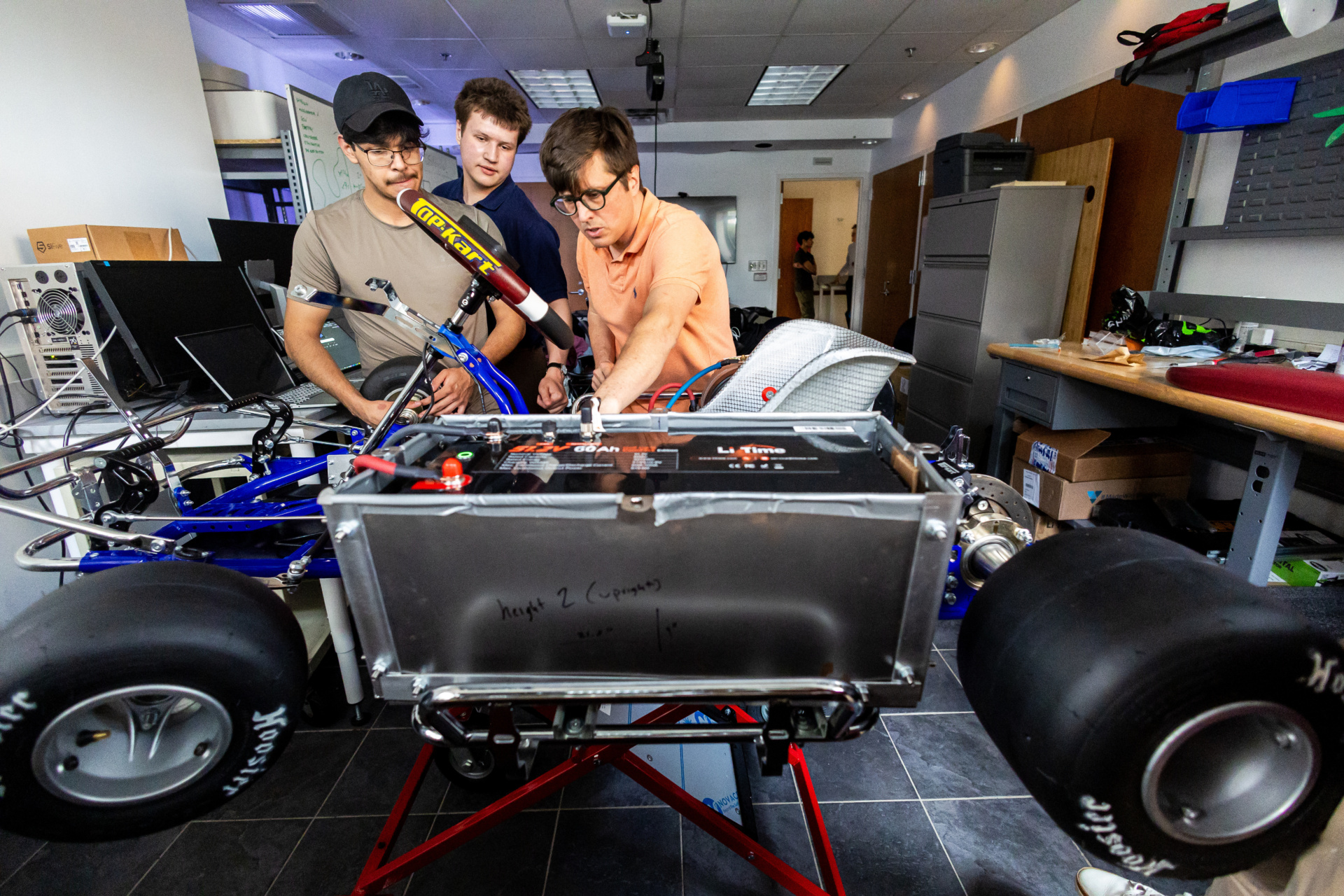 Loyola University Chicago students work on a small electric powered go-kart in a lab