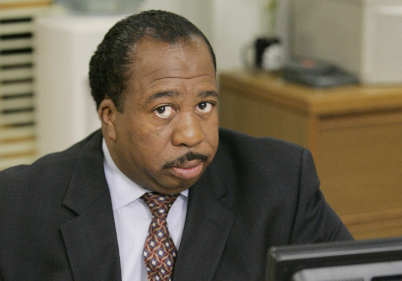 Leslie David Baker sits at a computer in an office while playing his role in the NBC television show 