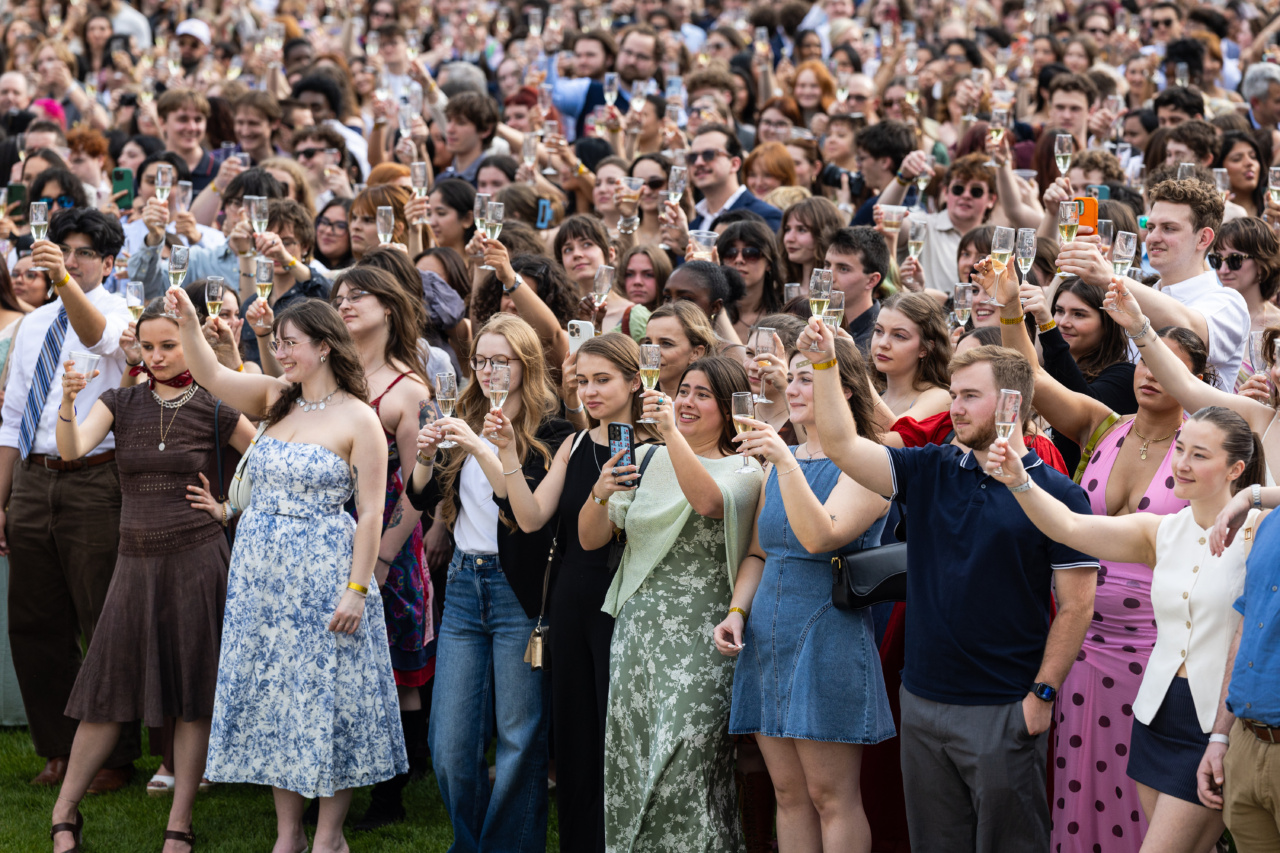 A crowd of Loyola University Chicago seniors holds champagne flutes in a toast outdoors