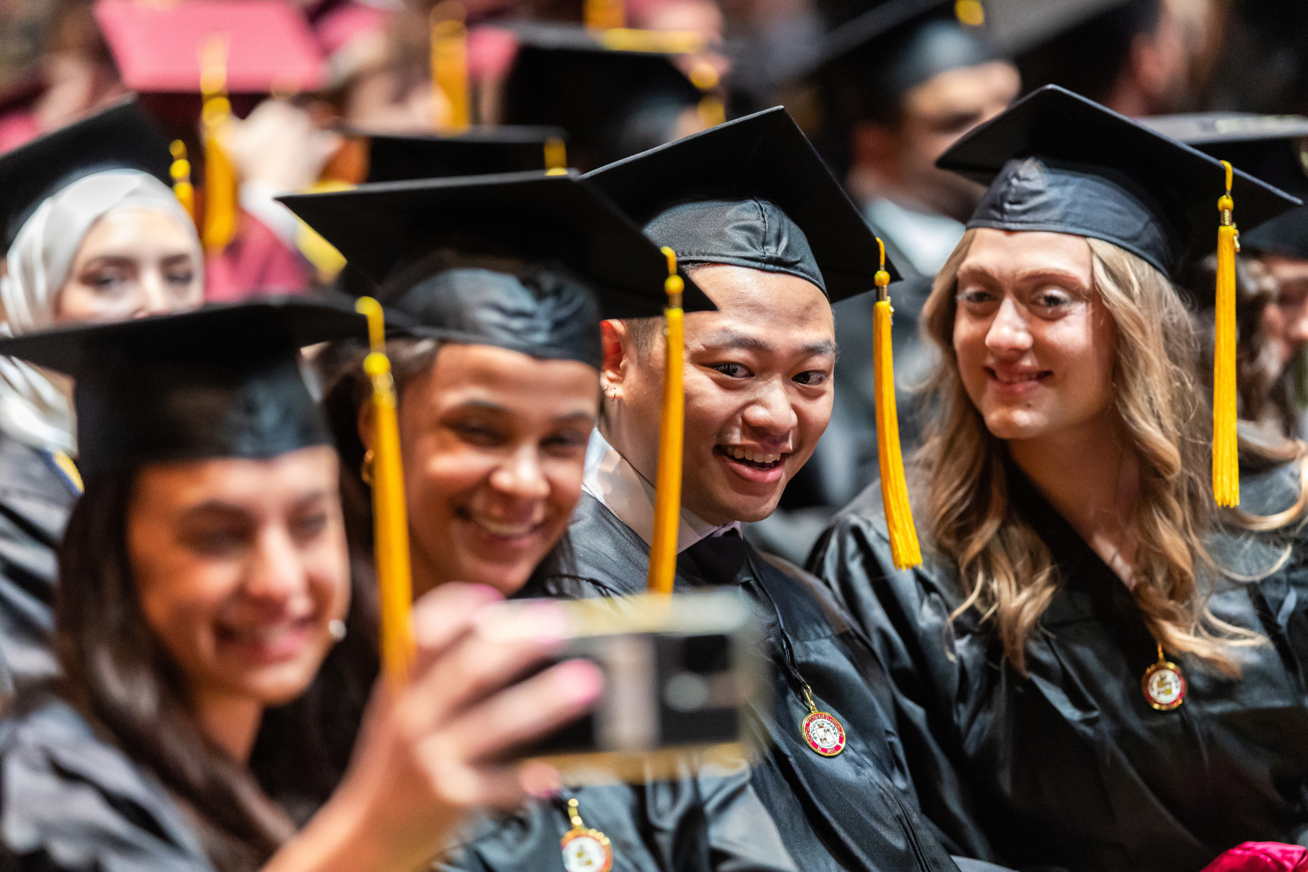 A group of graduates from Loyola's Class of 2026 take a selfie before the ceremony for the Parkinson School of Health Sciences and Public Health and the School of Social Work in Gentile Arena on May 6, 2026.