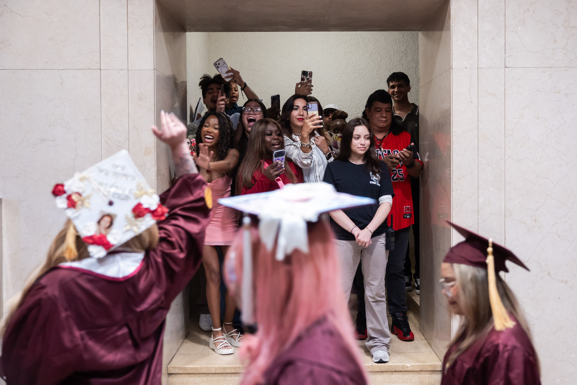 Family and friends cheer for graduates after the ceremony. 