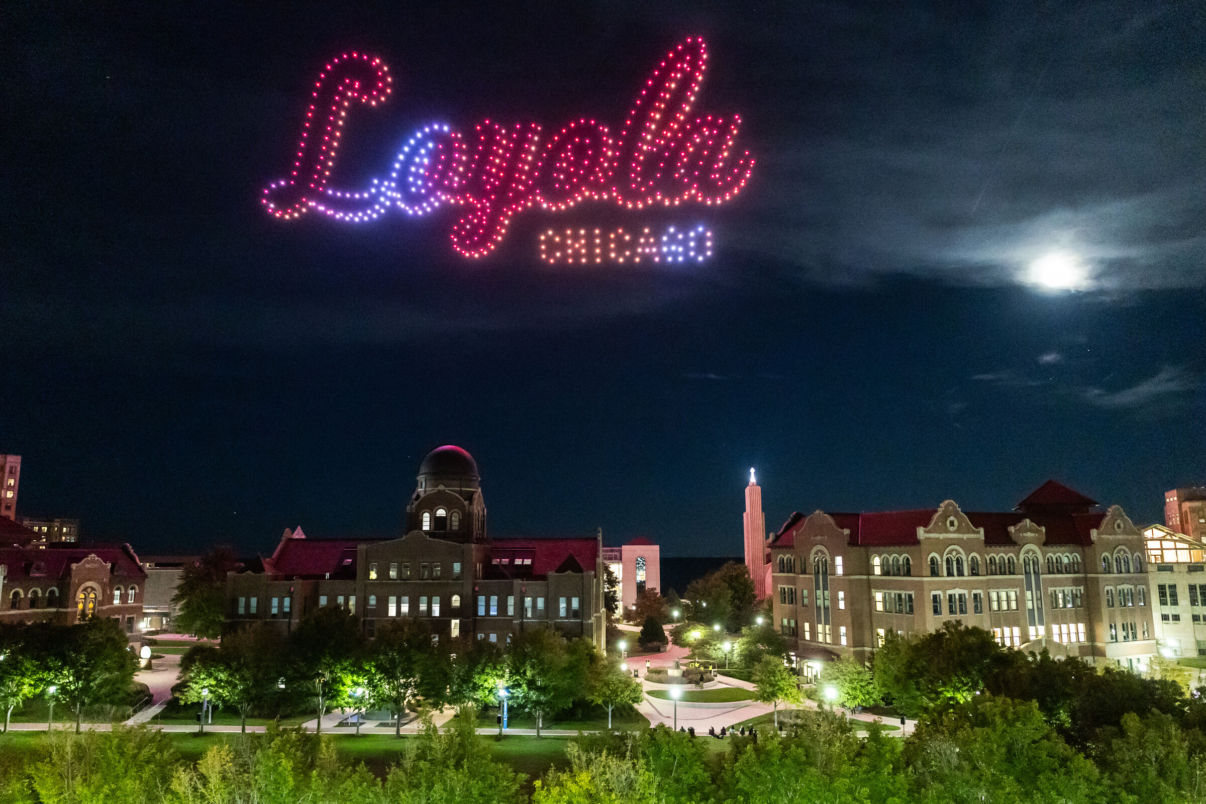 Loyola parents and students gather on the West Quad for a drone show during Family Weekend.