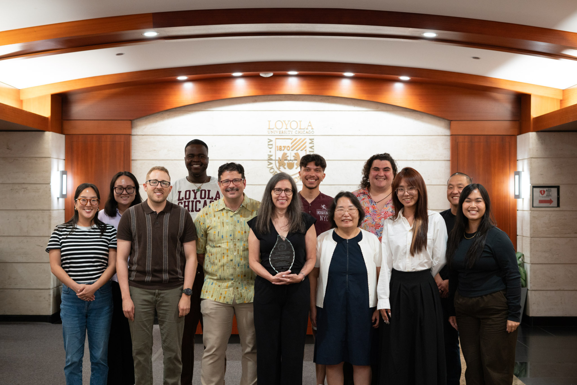 Elizabeth Vera, professor and co-chair of the Counseling Psychology PhD program, holds the award alongside faculty and students in the Counseling Psychology PhD program.